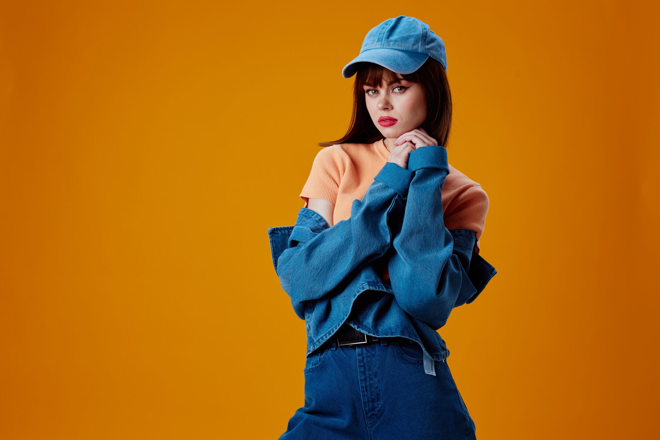 Beautiful fashionable girl denim cap red lips glamor fashion color background unaltered. High quality photo